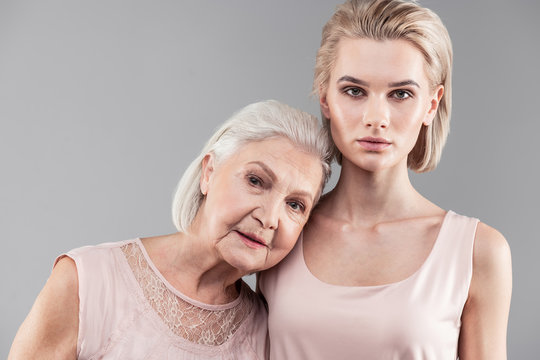 Grey-haired Female Pensioner Putting Her Head On Tiny Shoulder