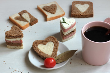 Delicious composition - sandwiches and bread in the form of hearts on the table
