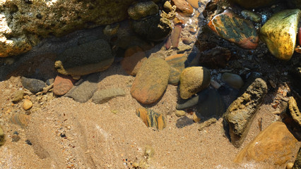 Stone reef on sand beach.