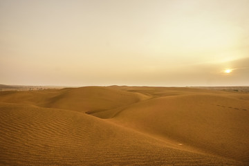 Fototapeta na wymiar Sunrise over the sand dunes of the desert in Rajasthan, India