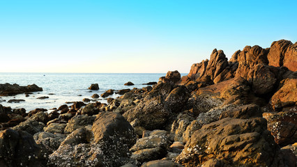 Stone reef beside beach and summer clear sky.