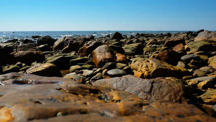 Stone reef beside beach and summer clear sky.