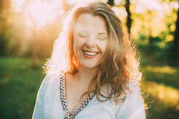 Portrait Of Happy Young Beautiful Pretty Plus Size Caucasian Girl Woman Dressed In White Blouse And Enjoying Life, Smiling, Having Fun In Summer Green Forest Park