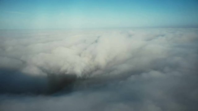 Dramatic aerial view of clear blue sky above dark storm hurricane vortex, panoramic view of massive thunderstorm forming