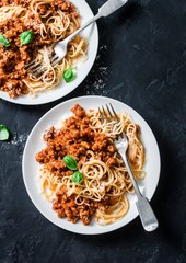 Mashed beans, mushrooms vegetarian bolognese sauce with spaghetti on a dark background, top view