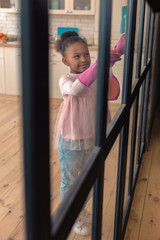African-American girl feeling involved in cleaning the glass door