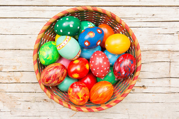 Easter background with handmade colored eggs on nest. Top view. Festive tradition