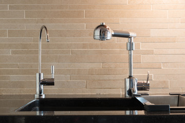Black artifical stone countertop with black sink and two faucets