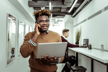 Smiling good-looking fit man working with different devices