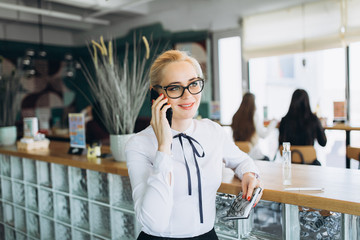 Blondie caucasian pretty young business woman in glasses in cafe 