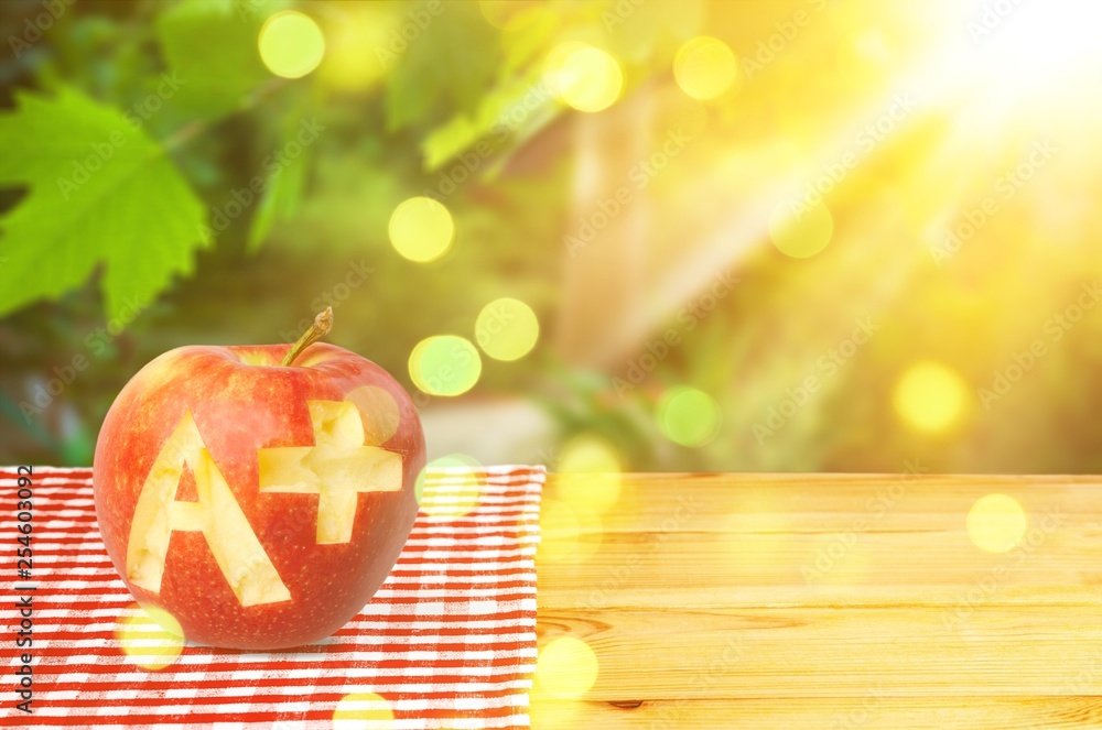 Wall mural photo of red apple with a+ on the school desk