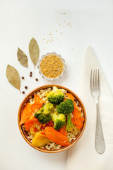 bulgur with vegetables and spices on a white background