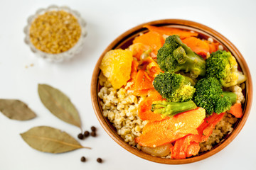 Bulgur with vegetables and spices on a white background