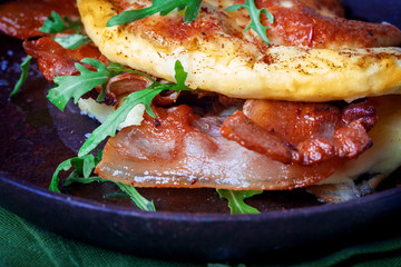 Delicious bacon omelette with arugula and colorful pickled tomatoes.Close up