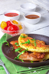 Delicious bacon omelette with arugula and colorful pickled tomatoes