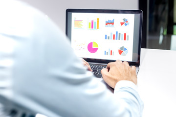 Businessman workspace laptop with coffee cup ,computer screen graphics and charts