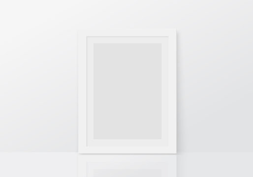 Mock up with vertical empty white frame standing on floor. Blank photo frame template.