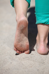 Feet of woman walking on the sand