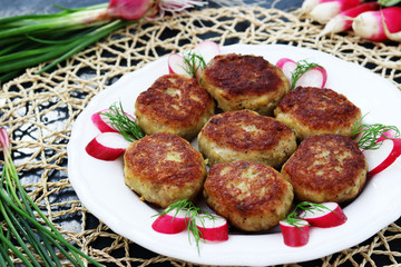 Fish patties on a white plate against a dark background