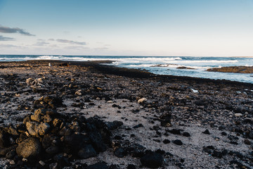 Scenic view of rocky beach  at sunset