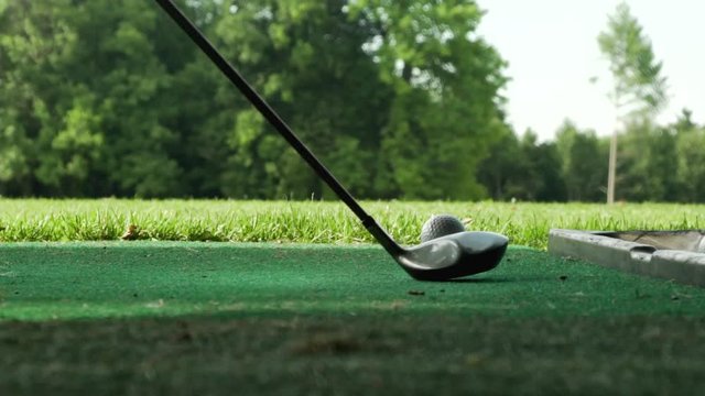 Driver shot slow motion- Club stike. Ball on tee. Driving Range. Trees in the Background. Swing