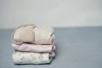 Colorful cotton folded clothes stack on white table empty space background,baby laundry.