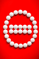 White pills arrange in stop sign. Red background. Medicine concept.