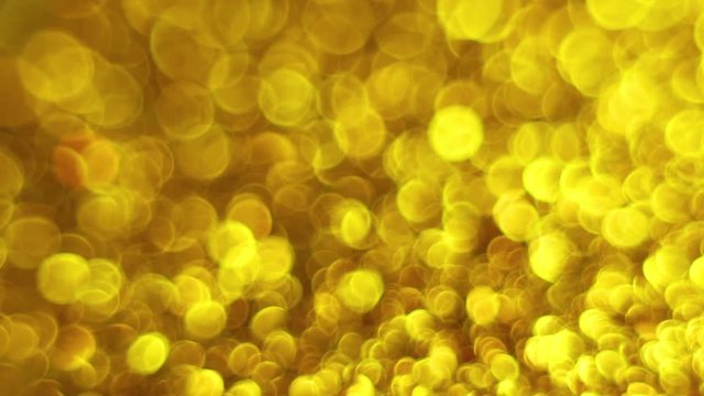 Golden abstract bokeh lights background. Magical Merry Christmas walpaper. Luxury shiny Full HD video for the New Year, Unniversary celebration and Wedding ceremony.