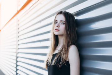 Cute cheerful portrait of young teenage girl outdoors in the street . Emotions, portrait, beauty concept