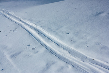 a fresh trail of skis on the snow