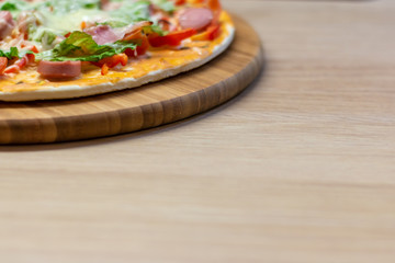 Side view homemade pizza with copy space on bright background with selective soft focus.