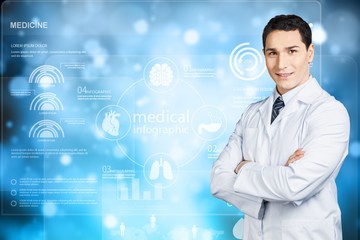 Handsome young male doctor in uniform standing with arms crossed on white background