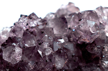 Gemstone Amethyst closeup as a part of cluster geode filled with rock Quartz crystals.