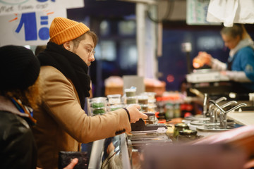 Contactless payment. A man pays with a phone on the market. Checkout Counter Customer Pays with Smartphone for His Items. Modern Wireless Paying Terminal System