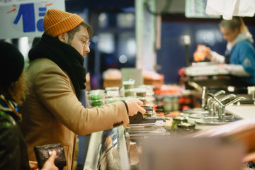 Contactless payment. A man pays with a phone on the market. Checkout Counter Customer Pays with Smartphone for His Items. Modern Wireless Paying Terminal System