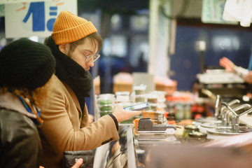 Contactless payment. A man pays with a phone on the market. Checkout Counter Customer Pays with Smartphone for His Items. Modern Wireless Paying Terminal System