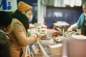 Contactless payment. A man pays with a phone on the market. Checkout Counter Customer Pays with...