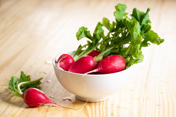 Fresh red radishes on wooden table