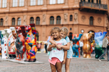 Two adorable little girls, sisters walking in old town in Riga together . Childhood, travelling concept