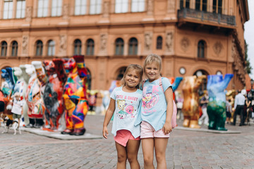 Two adorable little girls, sisters walking in old town in Riga together . Childhood, travelling concept