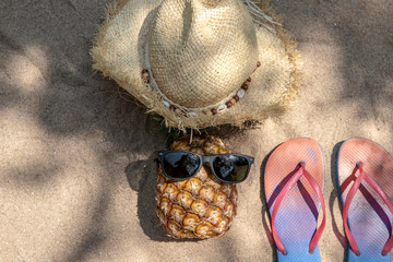 Summer vacation concept straw hat , pineapple fruit with sunglasses and  flip flop sandals  on...