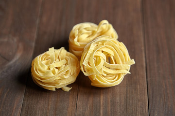 Tagliatelle italian pasta on brown wooden table