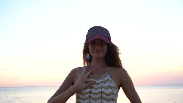 Young beauty girl dansing at tropical beach near sea water at paradise island at sunset, close up, slow motion. Summer concept. Holiday travel.