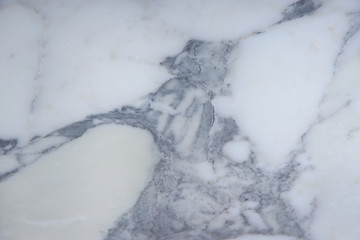 The beautiful surface of natural stone, light marble with a large gray pattern, is called Arabescato