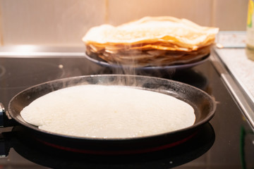 pancakes fry in a pan. the process of cooking pancakes on an electric stove