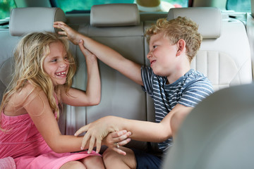 Zwei Kinder raufen und streiten im Auto