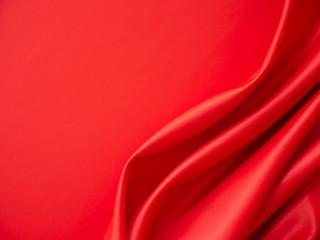 Beautiful smooth elegant wavy hot red satin silk luxury cloth fabric texture, abstract background design. Wallpaper, banner or card with copy space.