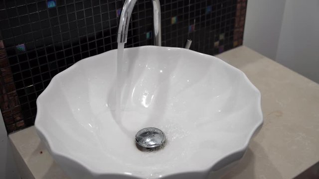 Tap water flows from the tap with a strong jet.