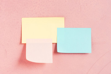 Three various paper sticks on the pink-coral textured wall