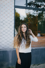 Young beautiful happy woman with long curly hair having free time outdoors